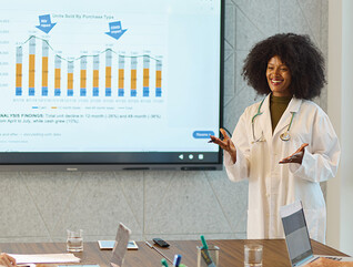 doctor gives presentation in front of chart