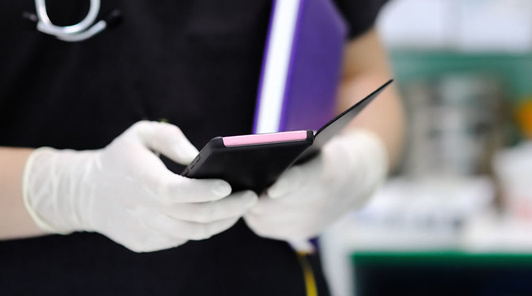 Nurse holding purple smartphone
