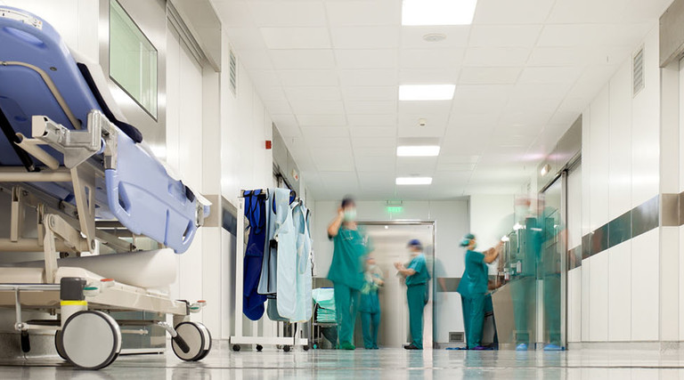 Blurred figures of people with medical uniforms in hospital corridor
