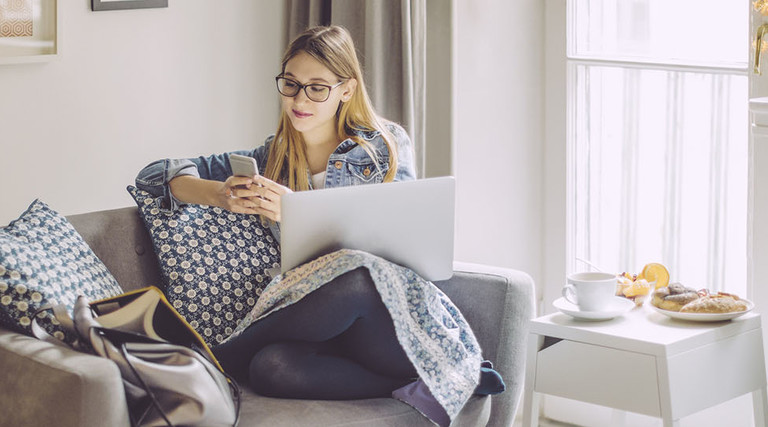 Young woman at home on computer