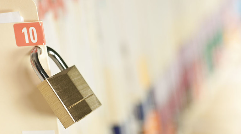 Secure and protected medical records. Bar code added to folder, not actual patient information. Concept image. Narrow depth of field.