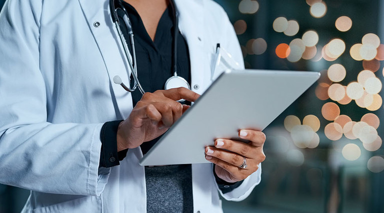 Closeup shot of an unrecognizable doctor using a digital tablet in a hospital at night