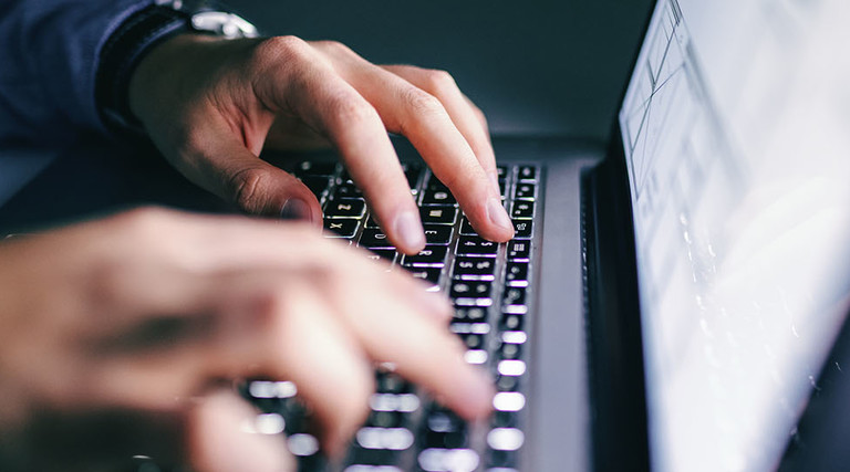 Person with hands on laptop screen