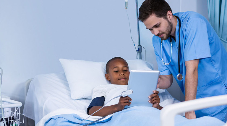 National Public Health Week — Male nurse and patient using digital tablet in ward