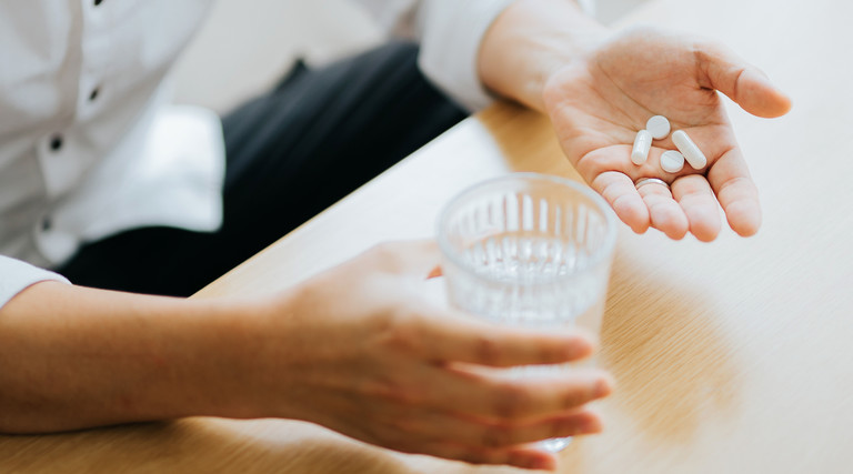 Man holds pill in hand