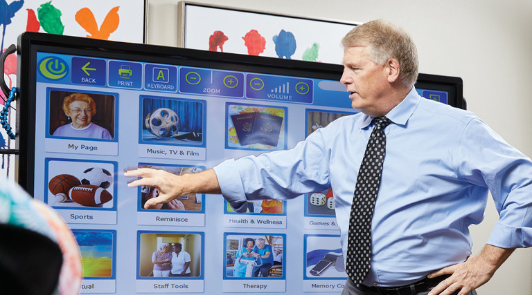 Chip Burns, CIO of Sun Health Communities, demonstrates interactive touch-screen technology that facilitates brain games, exercise routines and video chat, among other capabilities.