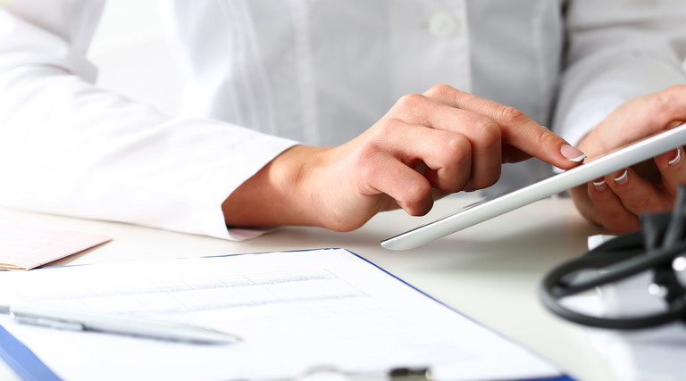 Doctor reads patient data on tablet