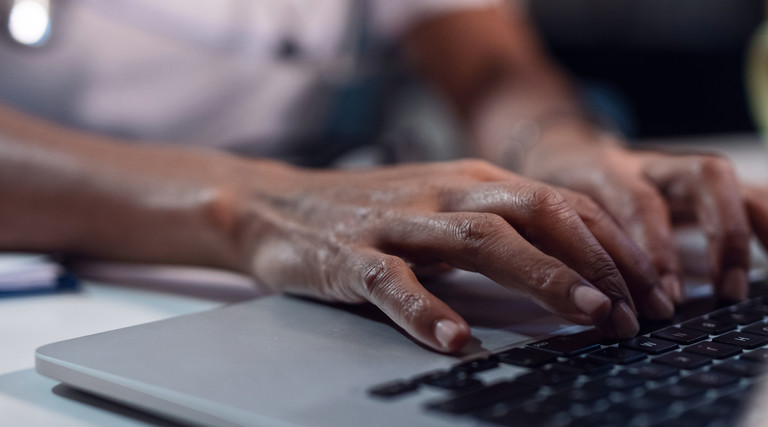 Doctor types on computer