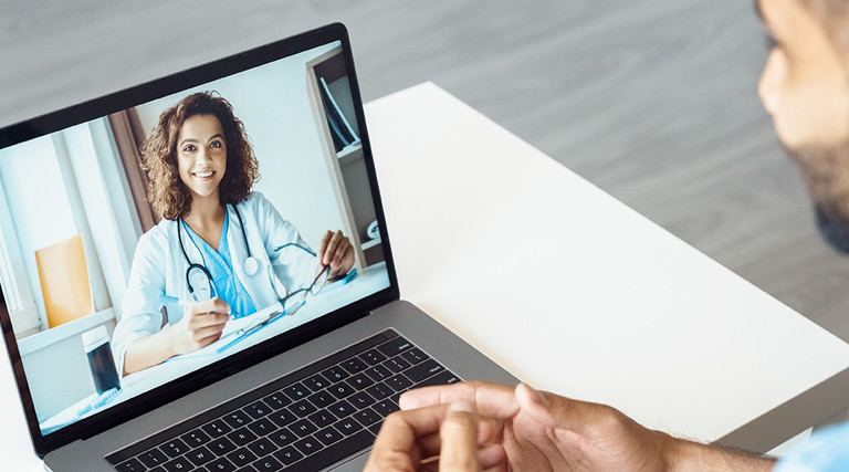 man attends telehealth appointment with doctor on laptop
