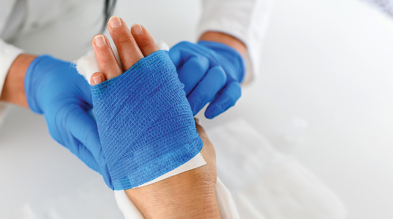 doctor dresses patient's wound on hand