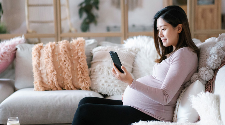 pregnant women looks at app on phone