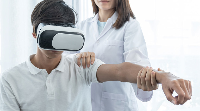 patient wears virtual reality goggles during physical therapy with doctor