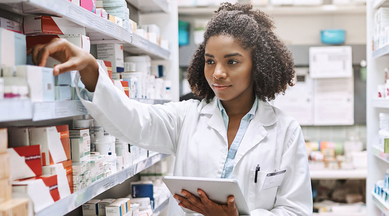Pharmacy technician uses a tablet to fulfill a prescription order