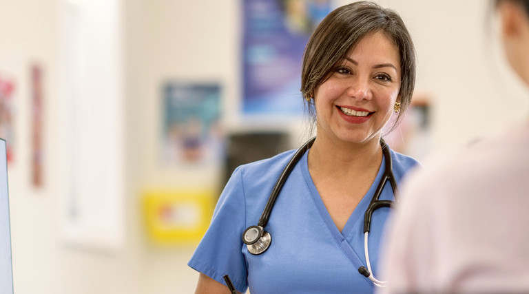 clinician talks to patient next to spine anatomy figure