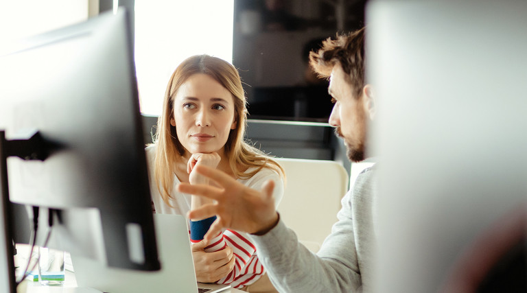 IT staff talk in front of monitor