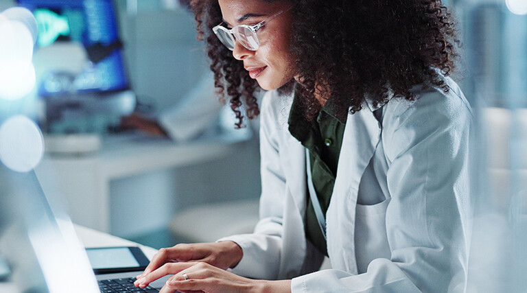 Doctor on laptop in state-of-the-art lab