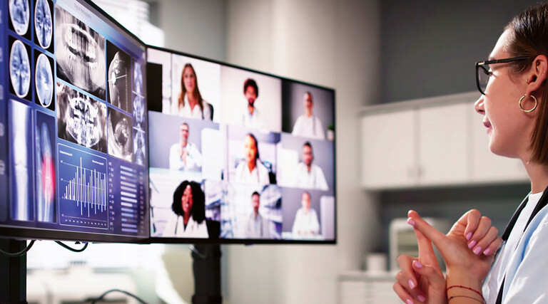 doctor on video call with several care team members