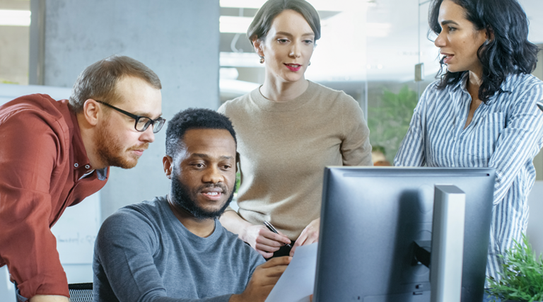 IT team discuss problem around computer