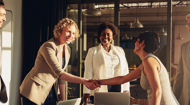 business leaders shake hands in conference room