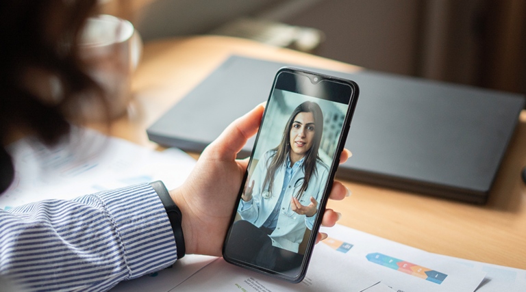 patient holds phone and speaks to doctor during telehealth appointment