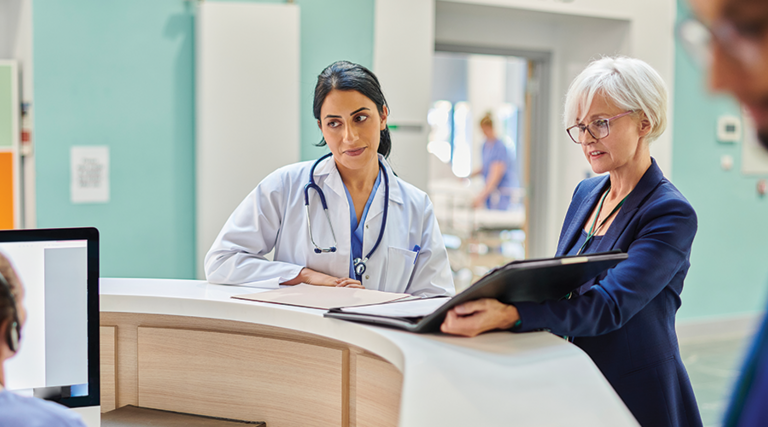 clinicians and administrators collaborate at hospital desk