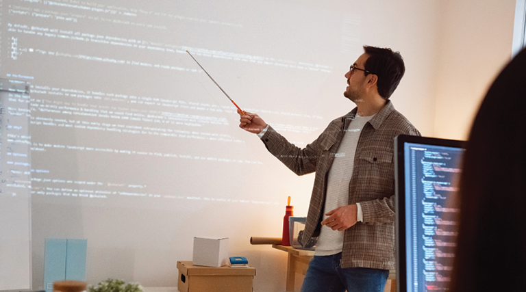 man teaches coding class using projector