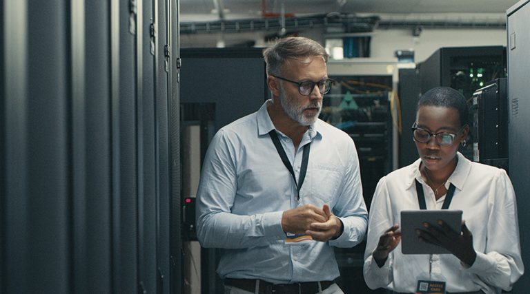 IT professionals look at tablet in data center room