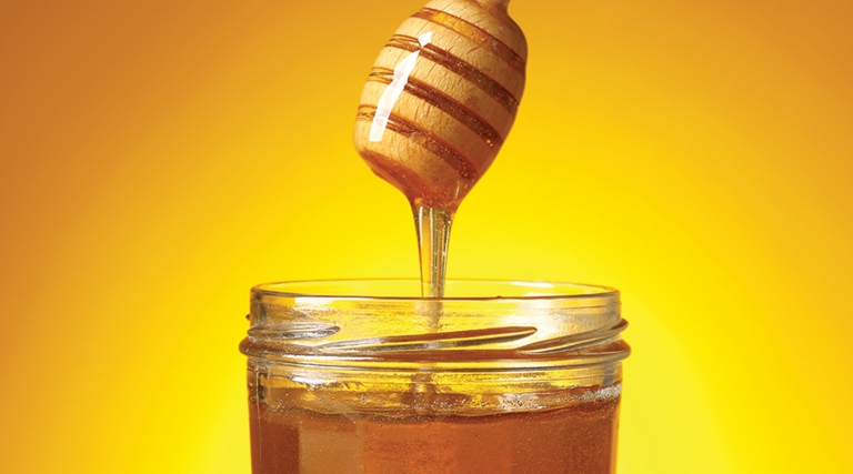 jar of honey with a honey dipper