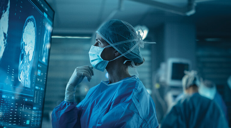 Surgeon looks at brain on a display in the OR
