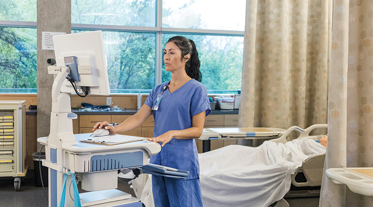 nurse on laptop in patient room