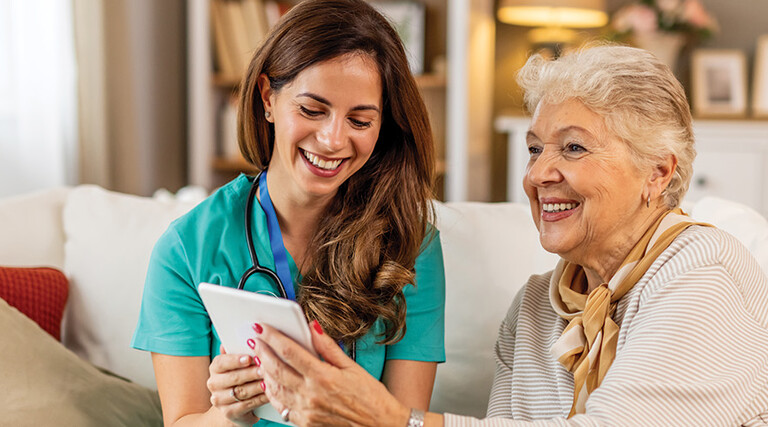nurse and senior look at technology