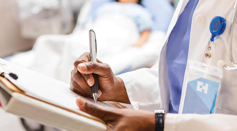 doctor uses paper charting in front of patient