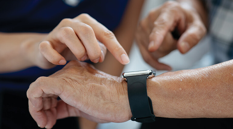 nurse helps man with wearable device