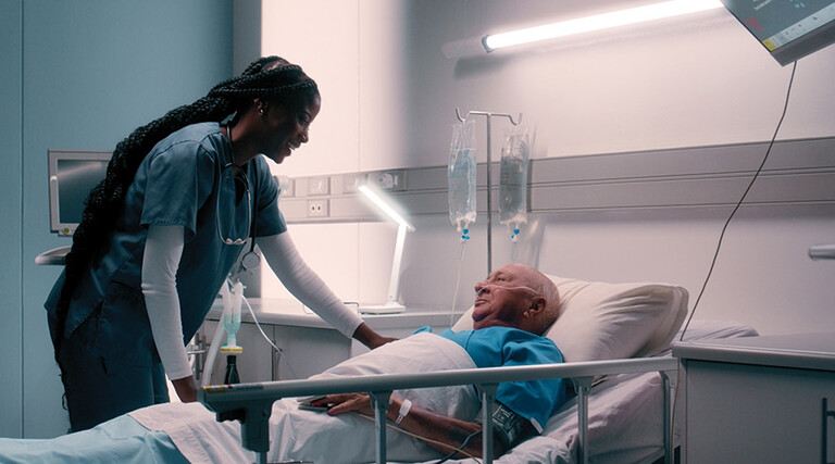 nurse talks to patient in hospital bed