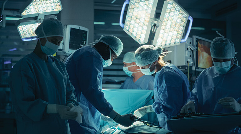 medical team performs surgery in dark room