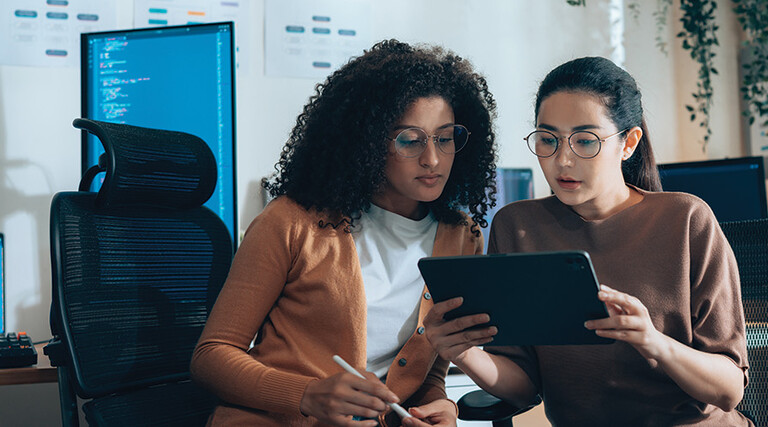 two IT leaders read document on tablet