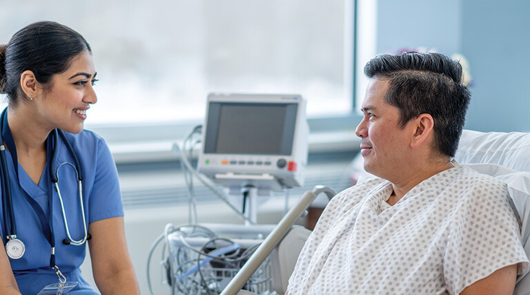 nurse talks with patient in hospital room