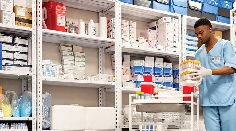 man grabs supplies in pharmacy supply room