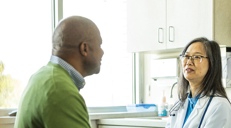 doctor talks with patient in exam room