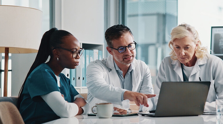 clinicians look at data on laptop