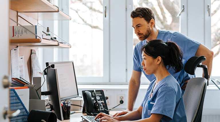 clinicians looking at computer monitor in office