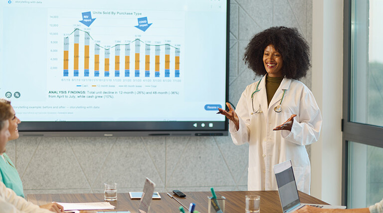 doctor gives presentation in front of chart