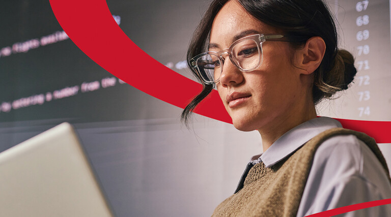 woman looks at laptop with screen of code behind her