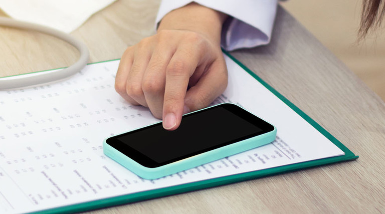 Doctor accesses patient data on smartphone as mobility in healthcare is on the rise