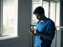 Shot of a focused young male doctor standing while being on his cellphone inside of a hospital