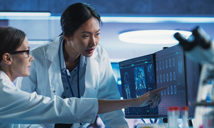 medical researchers looks at images on a monitor in a lab
