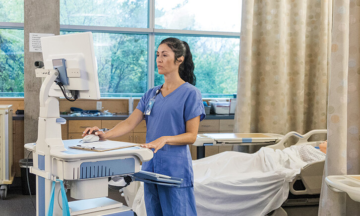 nurse on laptop in patient room