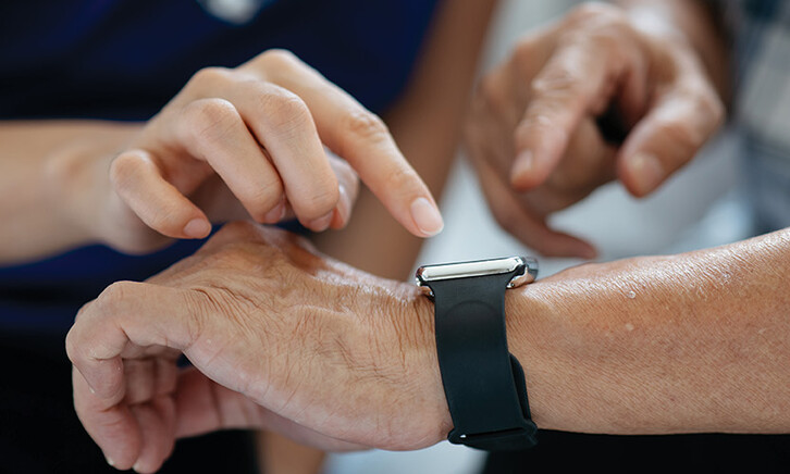 nurse helps man with wearable device