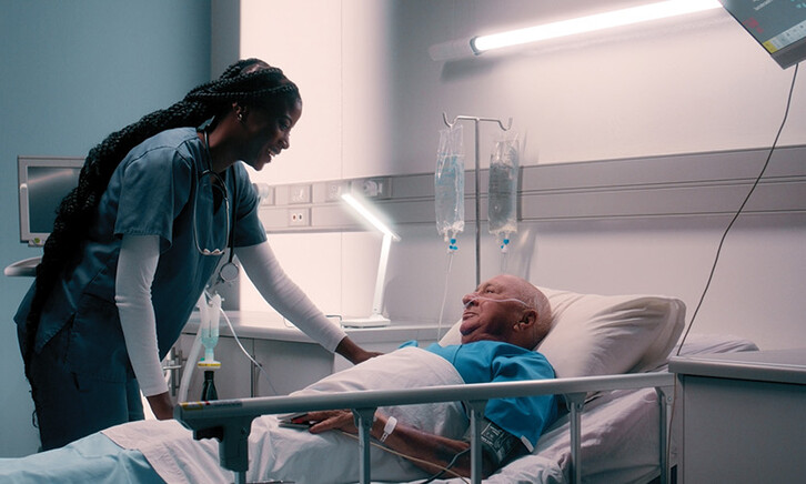 nurse talks to patient in hospital bed