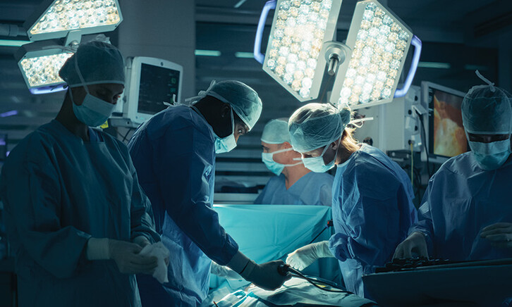 medical team performs surgery in dark room